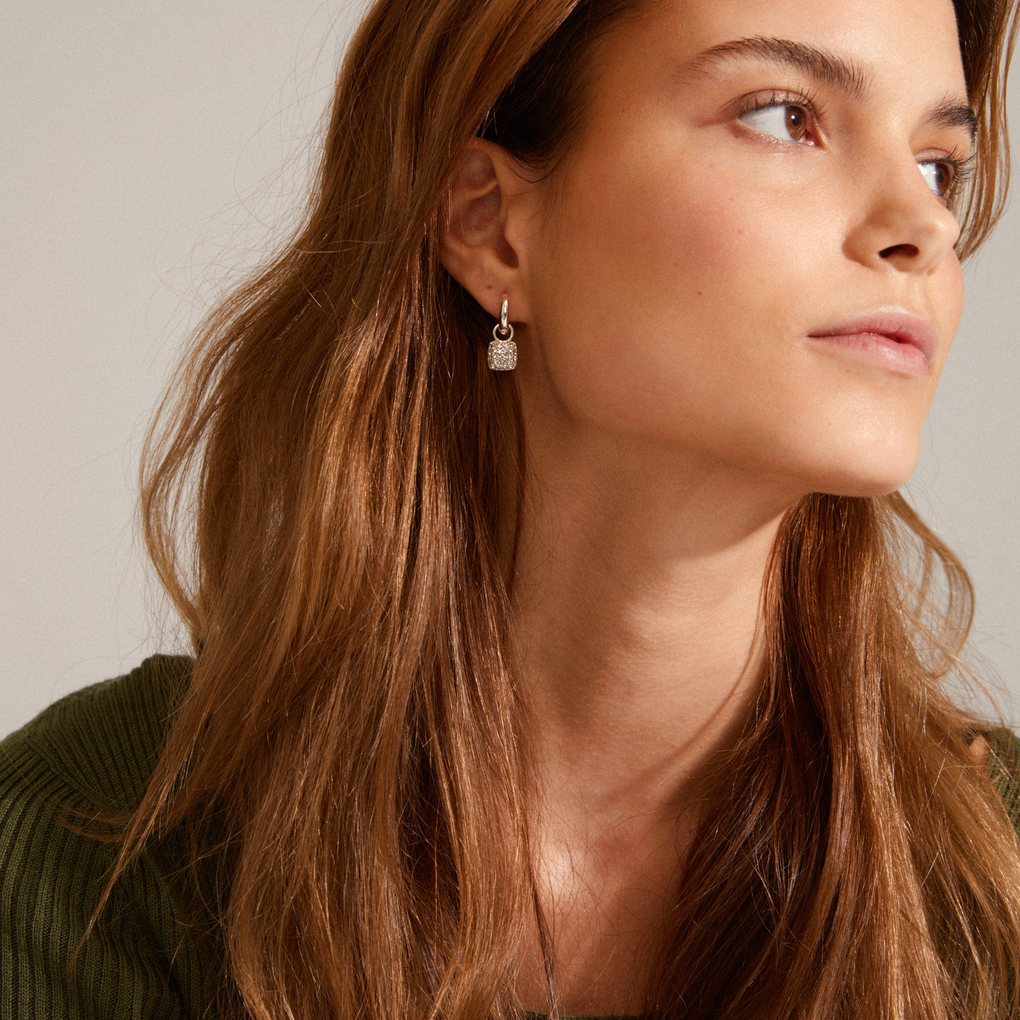 CINDY crystal hoop earrings, silver-plated with sparkling Preciosa crystals, worn by a woman, showcasing elegant design and subtle sparkle from Pilgrim.