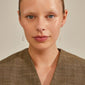 Close-up of a woman wearing REMY silver-plated chain earrings with a half moon pendant, highlighting their delicate, uneven design and minimalist appeal.