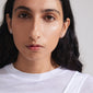 WRENLEY earrings: Silver-plated, fluid cable chain design with sparkling Preciosa crystals, visible on a woman wearing a white shirt. Elegant and versatile.