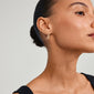 Close-up of a woman's ear wearing Pilgrim's TRUST gold-plated hoop earring, showcasing its elegant, organic design.