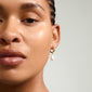 Close-up of a woman's face highlighting JONNE pearl earrings, 2-in-1 set, gold-plated with freshwater pearls, showcasing Pilgrim's timeless Scandinavian craftsmanship.