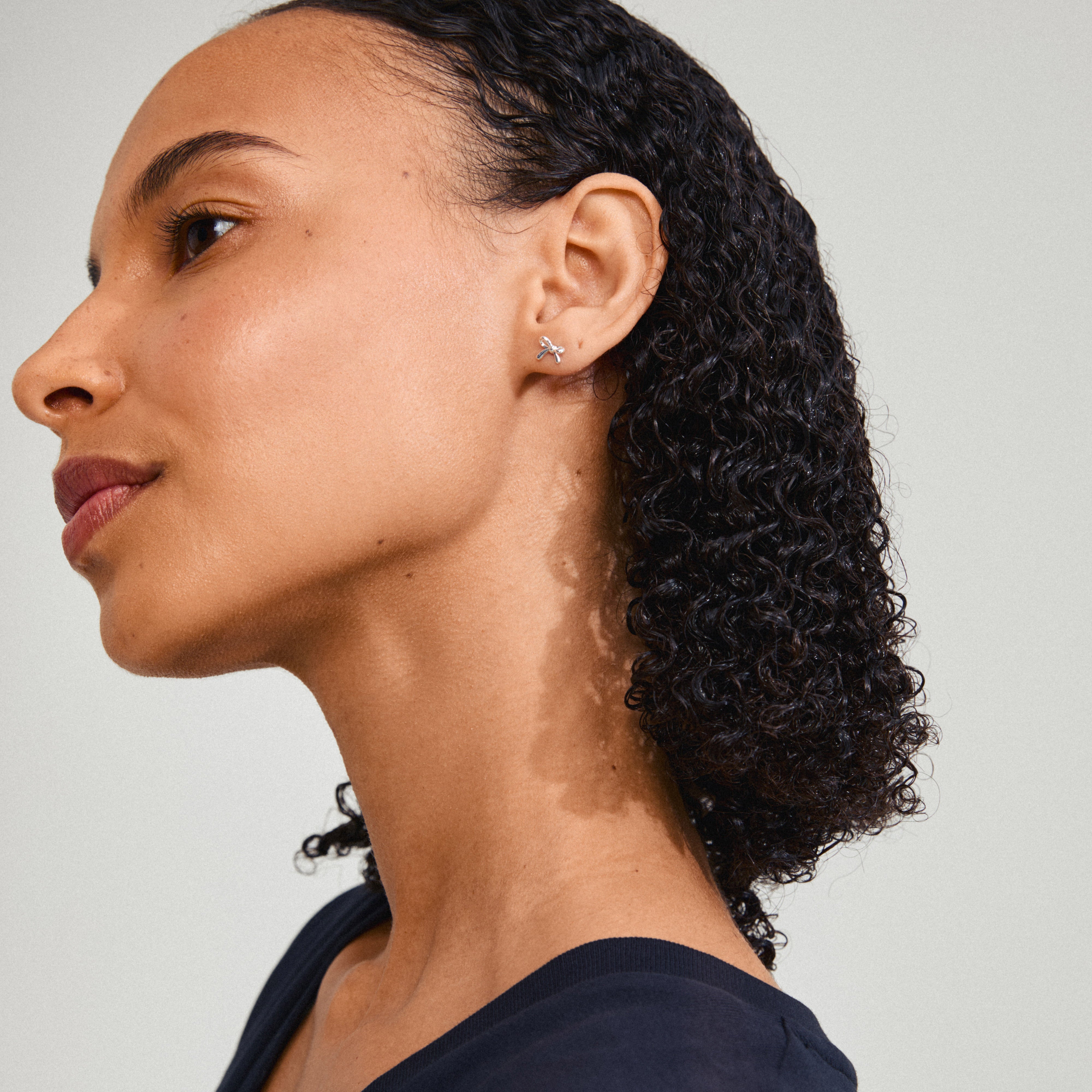 Close-up of LYSANDRA earrings, silver-plated bow studs, highlighting trendy design and eco-friendly materials, perfect for everyday style.