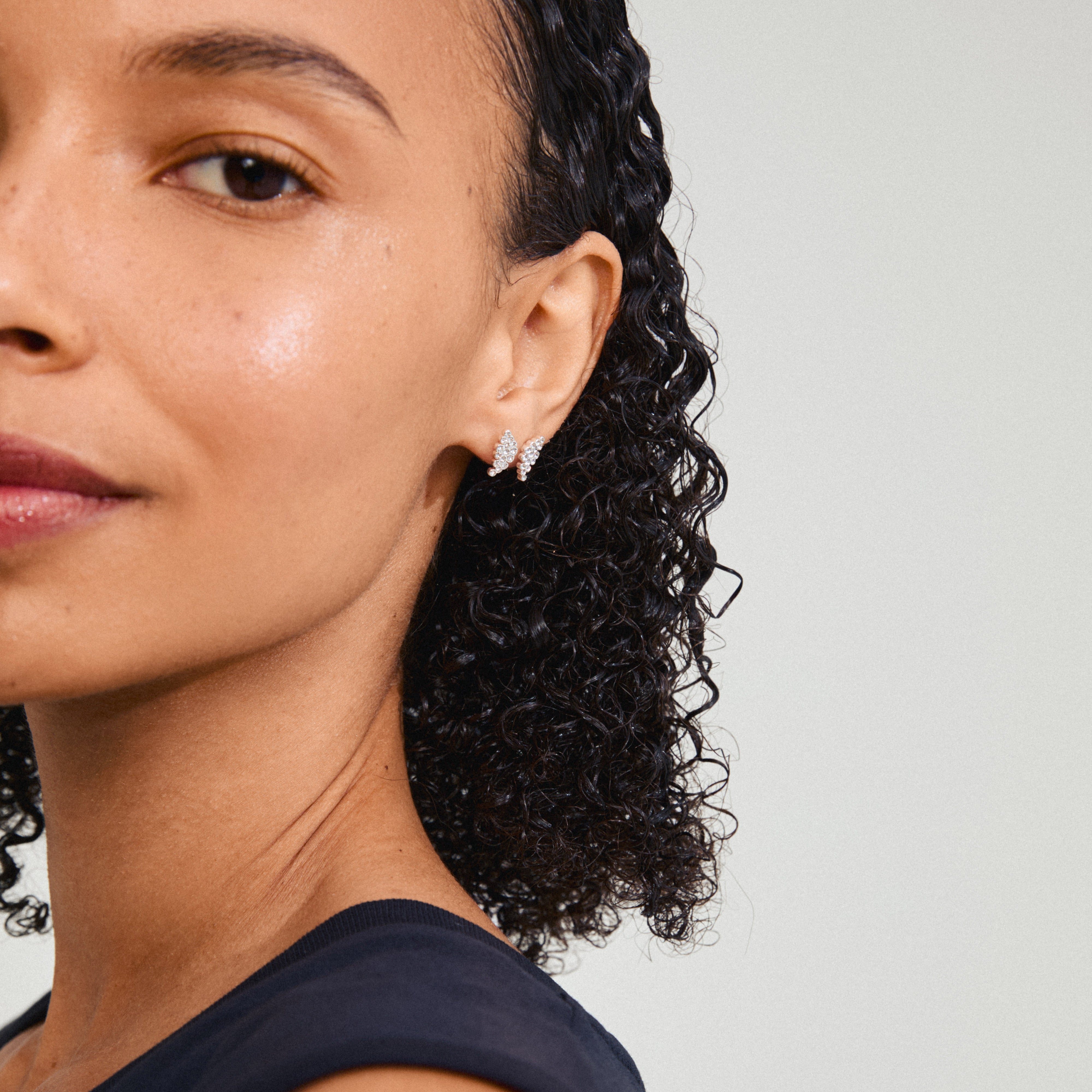 BERENIKE earrings silver-plated, close-up of a woman's ear showcasing small crystal studs with sparkling Preciosa crystals, offering a sophisticated and timeless look.