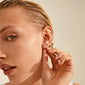 KAMARI crystal stud earrings set gold-plated adorns a woman's ear, reflecting timeless elegance and friendship, perfect for sharing with loved ones.
