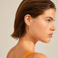 Profile view of a woman showcasing EDURNE crystal hoop earrings, rose gold-plated, with engraved floral prints and Preciosa crystals, embodying Pilgrim's timeless style.