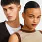 EANNA huggie hoops gold-plated worn by a young man and woman with stylish, minimalistic fashion, showcasing their timeless, versatile design and subtle elegance.