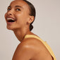A woman joyfully wearing EANNA large gold-plated hoops, showcasing their elegant design and simplicity, perfect for personal styling and versatile jewelry collections.
