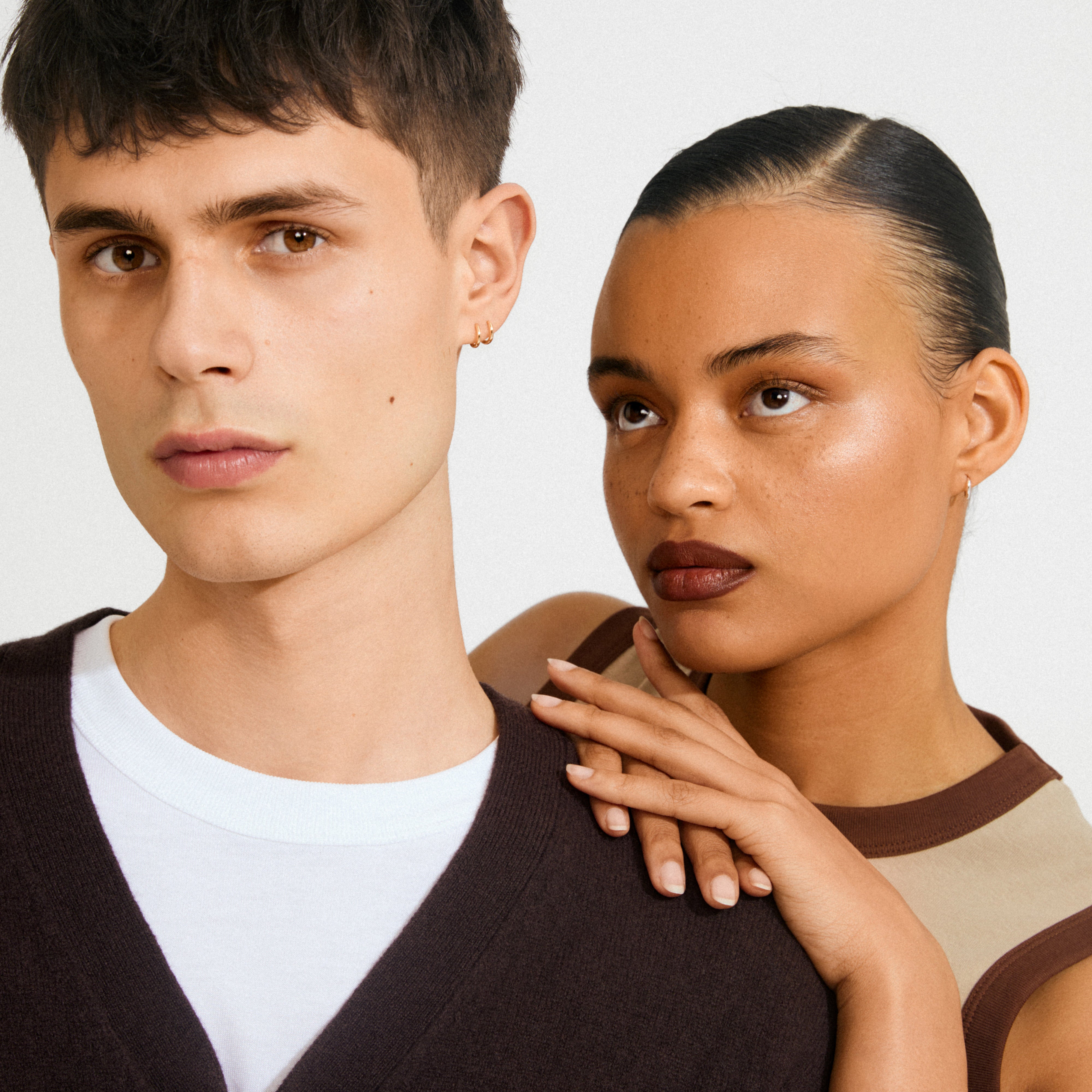 Young man and woman wearing EANNA huggie hoops silver-plated, showcasing minimalist style with small hoop earrings, emphasizing timeless and trendy Scandinavian design.