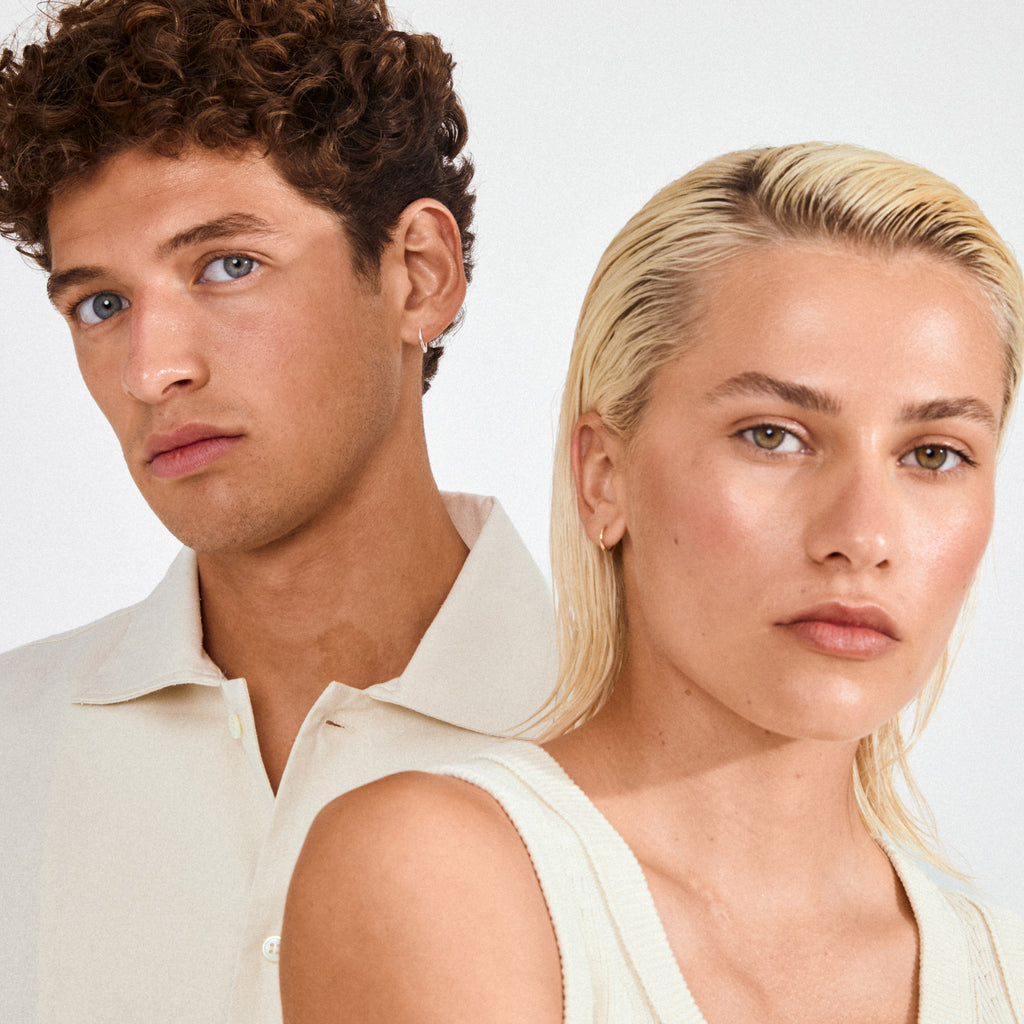 Two young adults wearing EANNA small hoops silver-plated earrings. The minimal design complements their casual tops, embodying Pilgrim's timeless, trendy style.