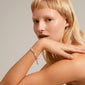 Close-up of a blonde woman wearing the silver-plated DESIREE bracelet by Pilgrim, showcasing its elegant design and recycled craftsmanship.