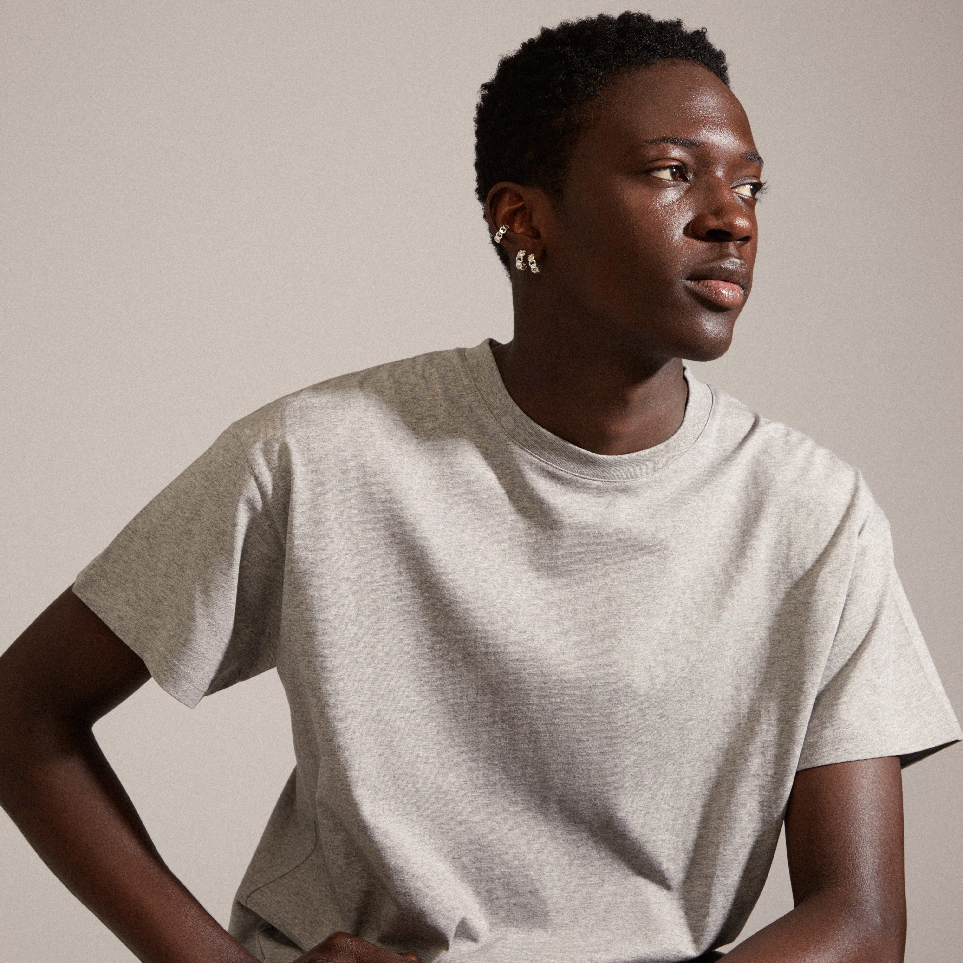DESIREE silver-plated hoop and cuff earrings feature a unique chain design with cubes and round links, worn by a man in a grey shirt.