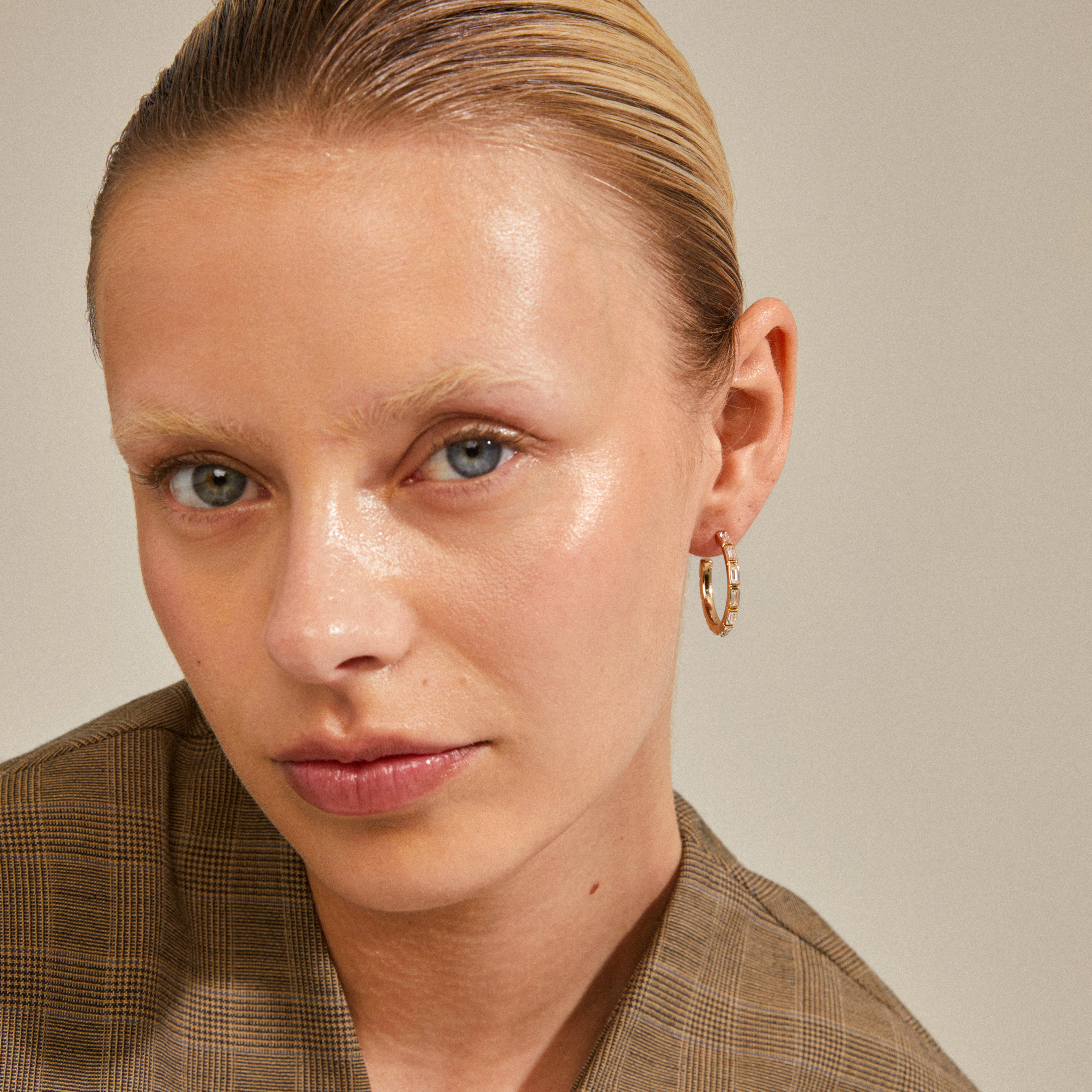 RUE recycled gold-plated hoops with sparkling glass stones worn by a woman, showcasing a chic and trendy party accessory.