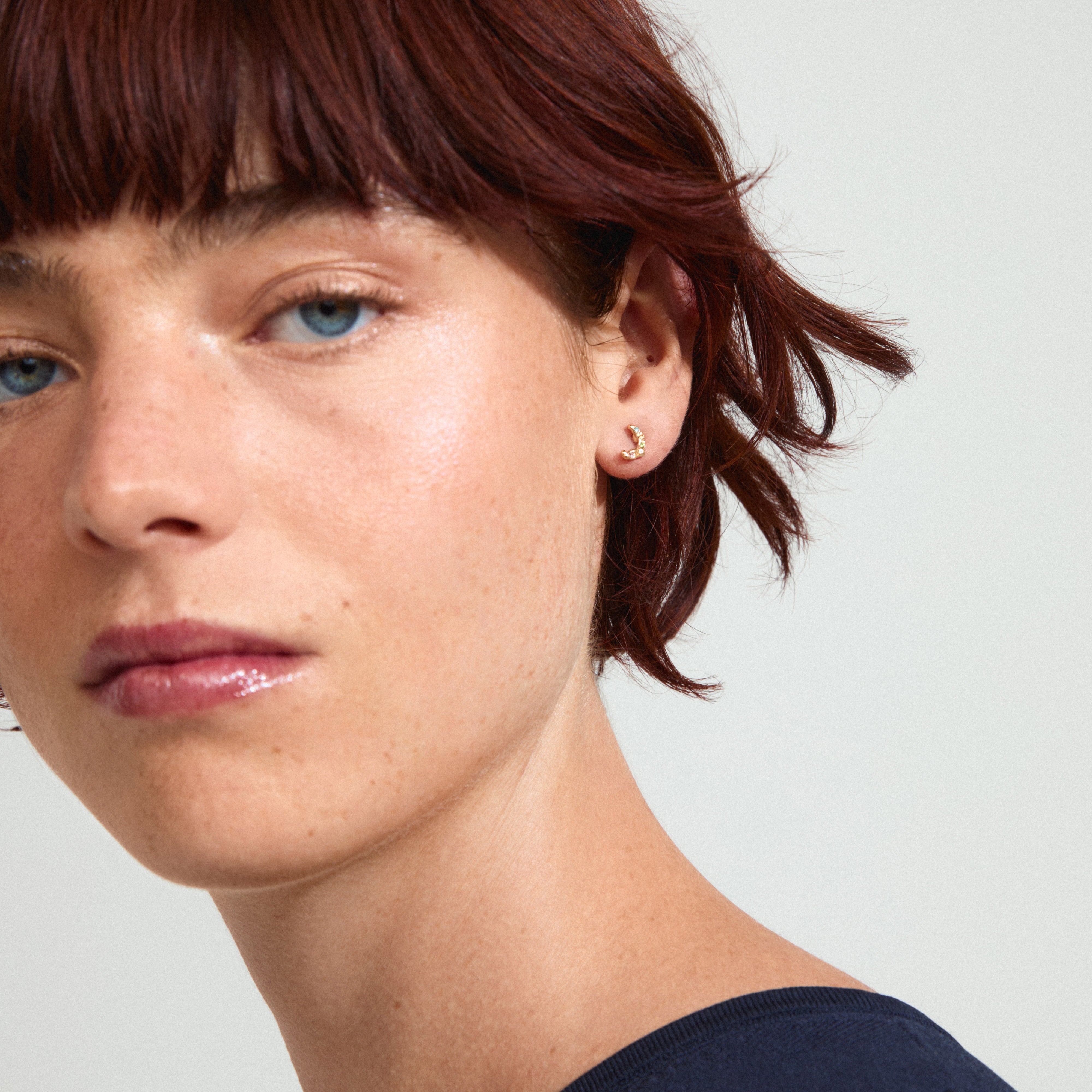 KORA earrings gold-plated, featuring colorful Preciosa crystals, highlighted on a woman with short red hair, showcasing their elegant and trendy design.