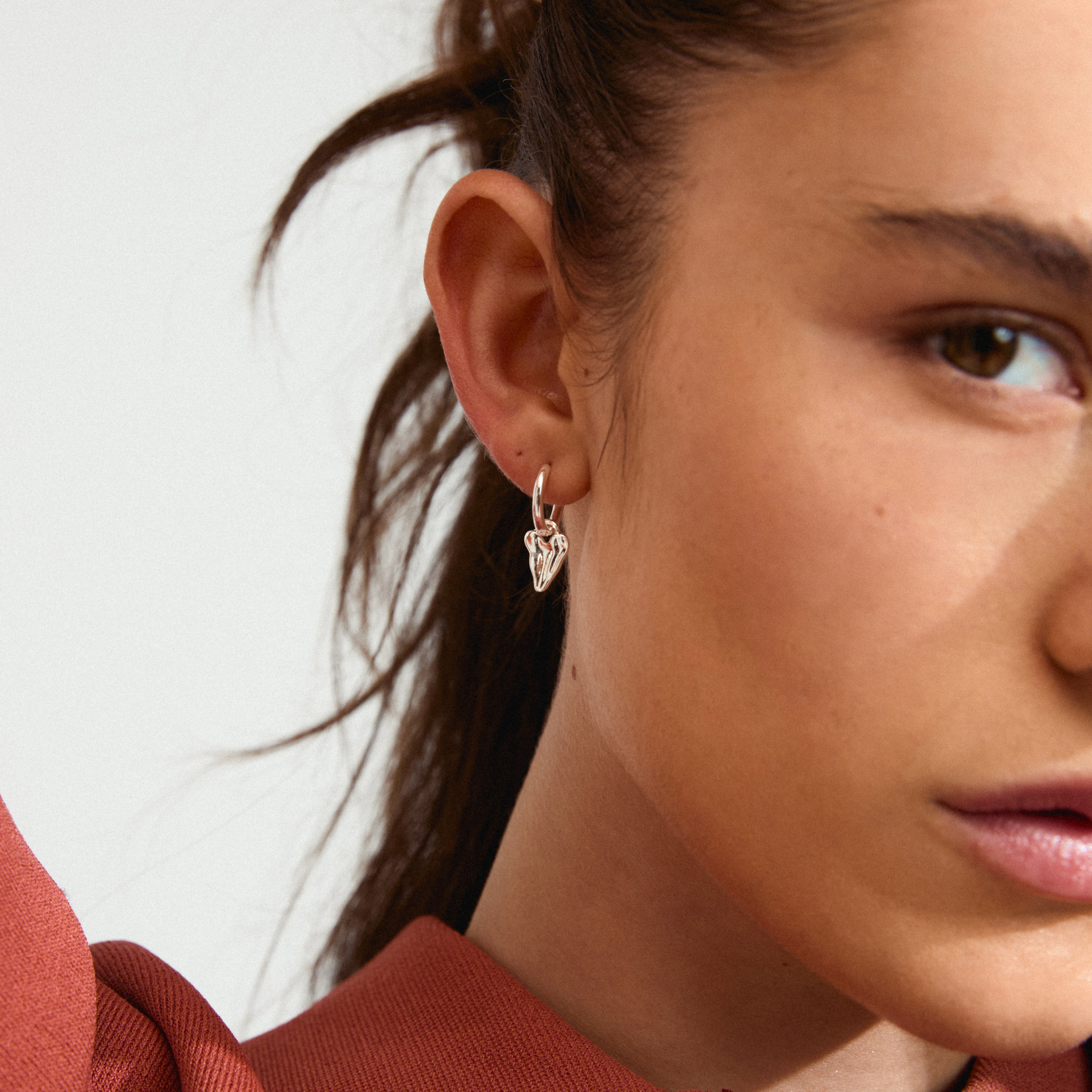 JULES earrings silver-plated, featuring classic hoops with a small, organic-design heart pendant, perfect for a trendy, asymmetrical look.