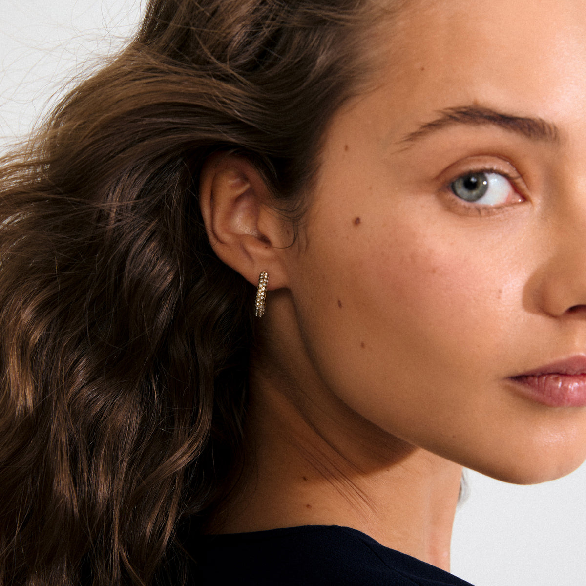 Gold-plated TATUM medium hoops adorned with Preciosa crystals, featuring snap locks for comfort and style; crafted from 97% recycled materials for eco-conscious fashion.