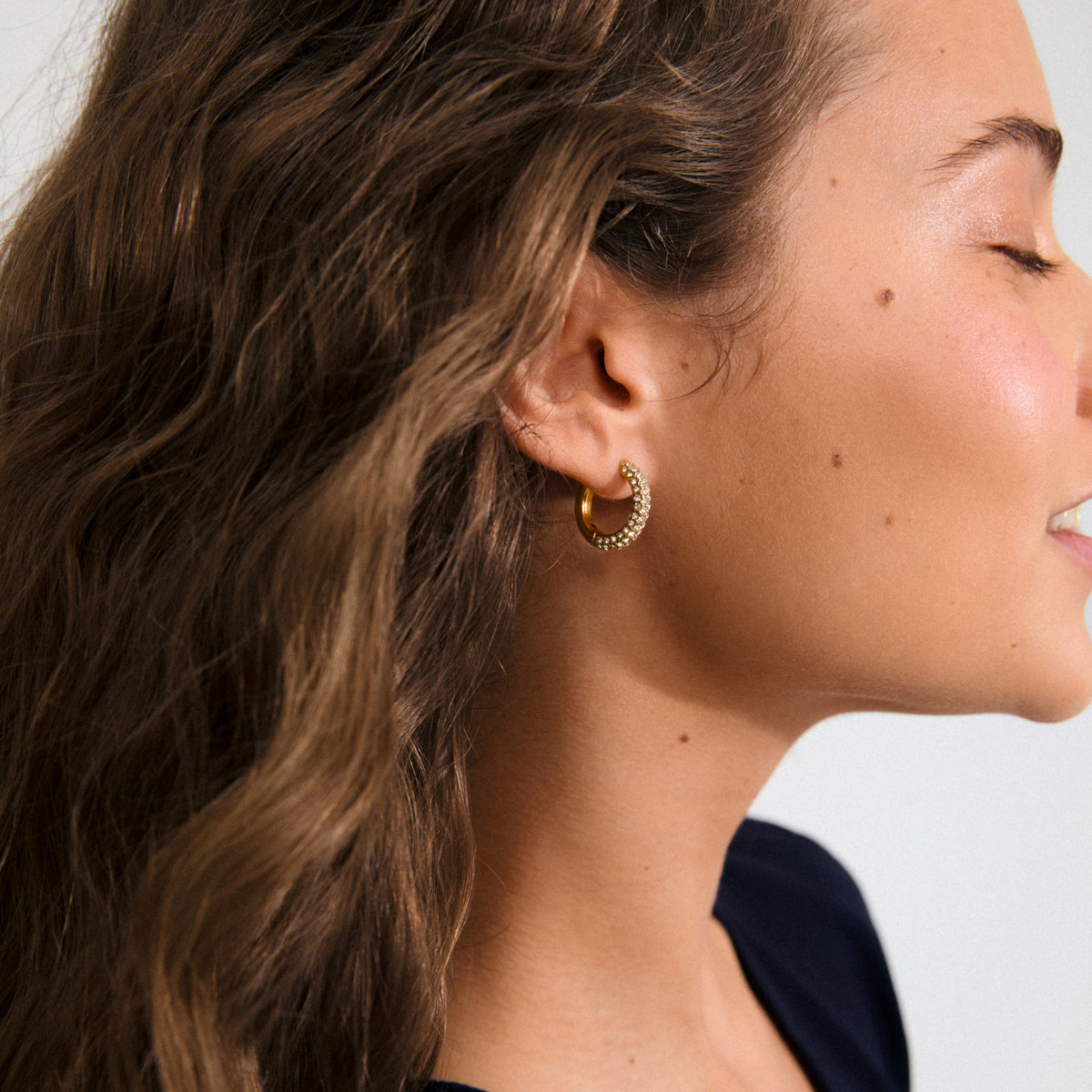 TATUM medium hoops, gold-plated, feature sparkling Preciosa crystals and snap locks for easy styling. Made from 97% recycled materials, perfect for day-to-night elegance.