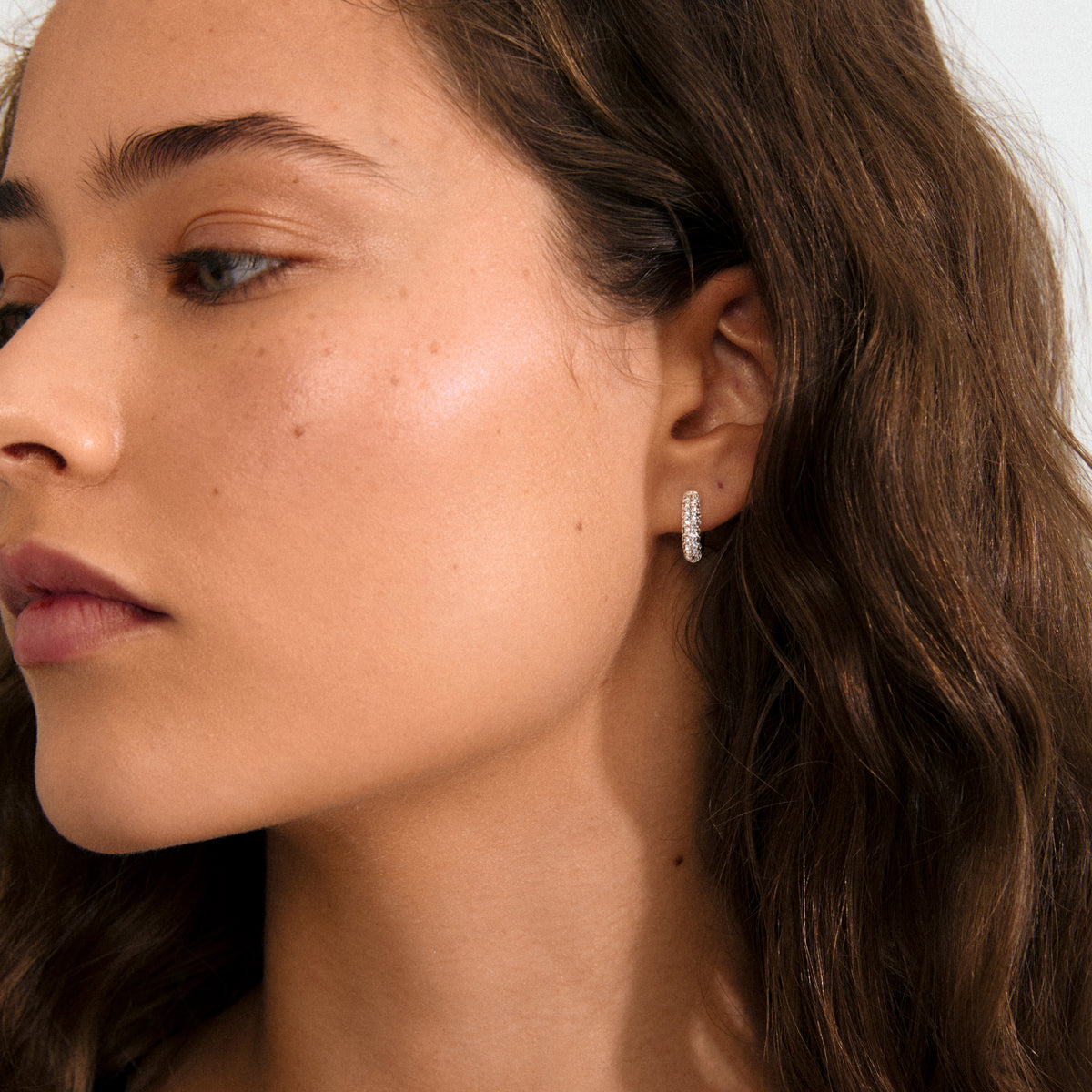TATUM small hoops silver-plated, featuring sparkling Preciosa crystals, offer understated luxury and versatility with easy click clasps, crafted from 96% recycled material.