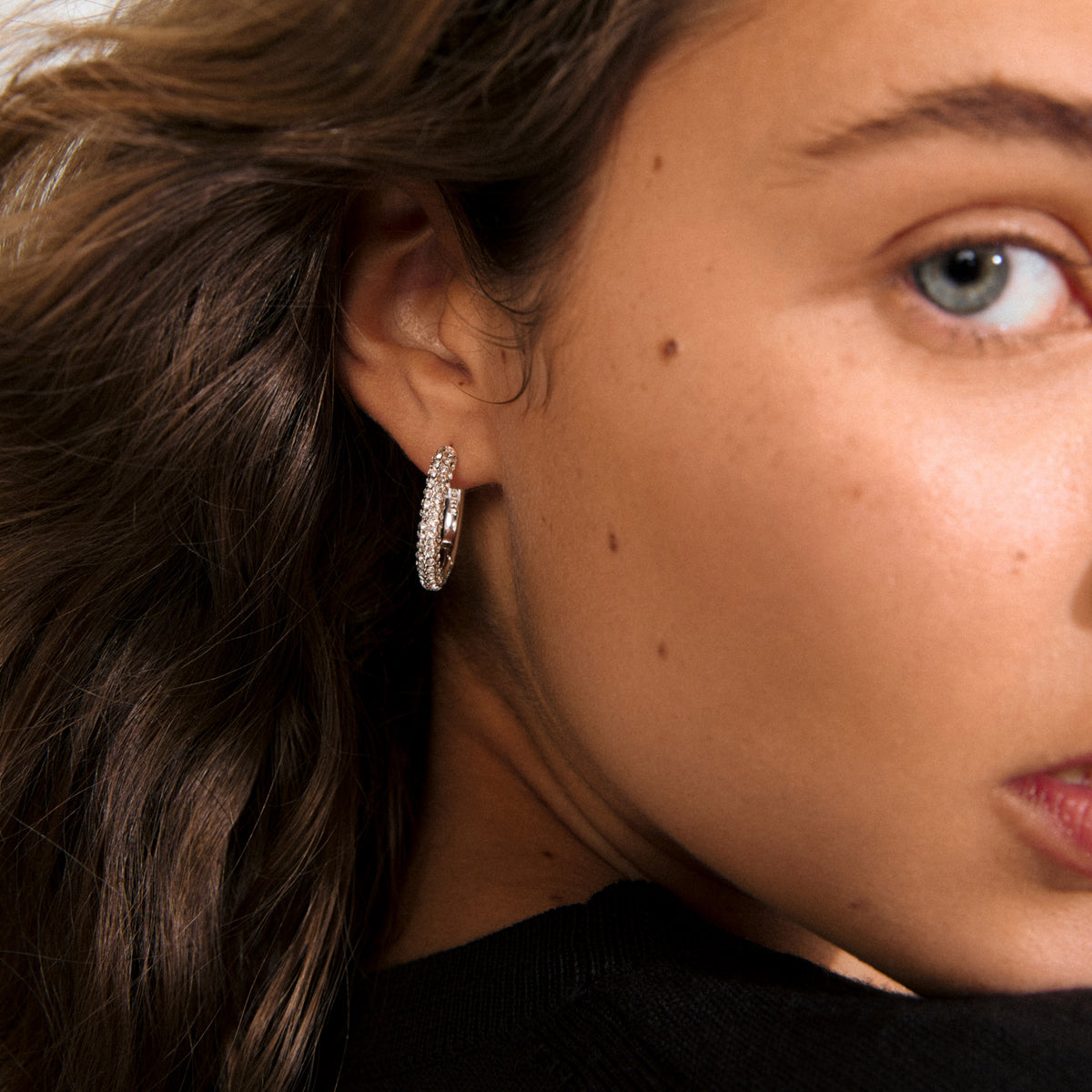 TATUM large hoops silver-plated with sparkling Preciosa crystals, offering understated luxury for versatile day-to-night elegance. Features easy click clasps, crafted from 97% recycled material.
