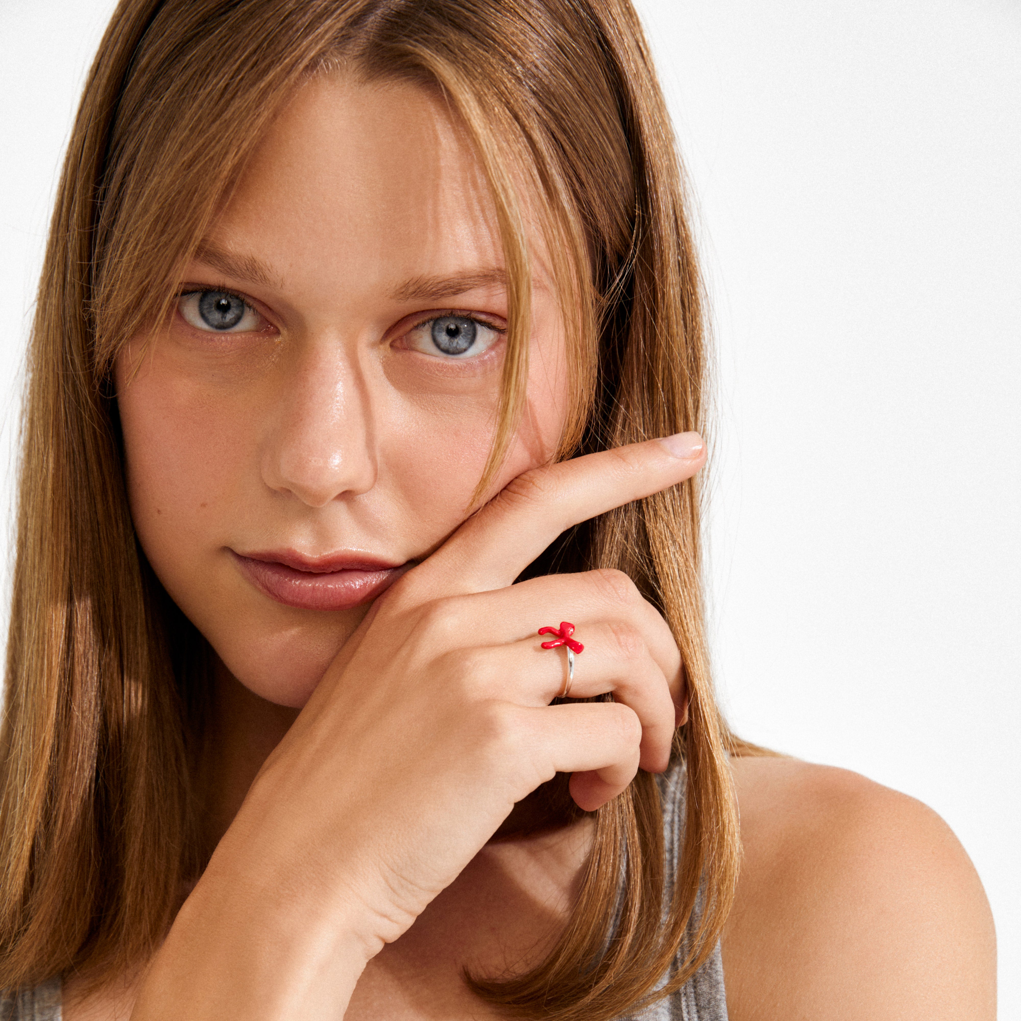 Young woman wearing the SIGRUN silver-plated ring with a red balloon-animal motif on her finger, highlighting its playful and stylish design.
