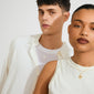 Two models showcase the DAGMAR pendant necklace gold-plated, featuring delicate floral-style cross pendants, highlighting Pilgrim's blend of timeless Danish elegance and modern style.