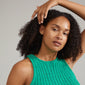 Woman wearing EMANUELLE earrings 3-in-1 set, gold-plated, featuring interchangeable crystal studs, gold-plated handcrafted earrings, and twirly huggie hoops.