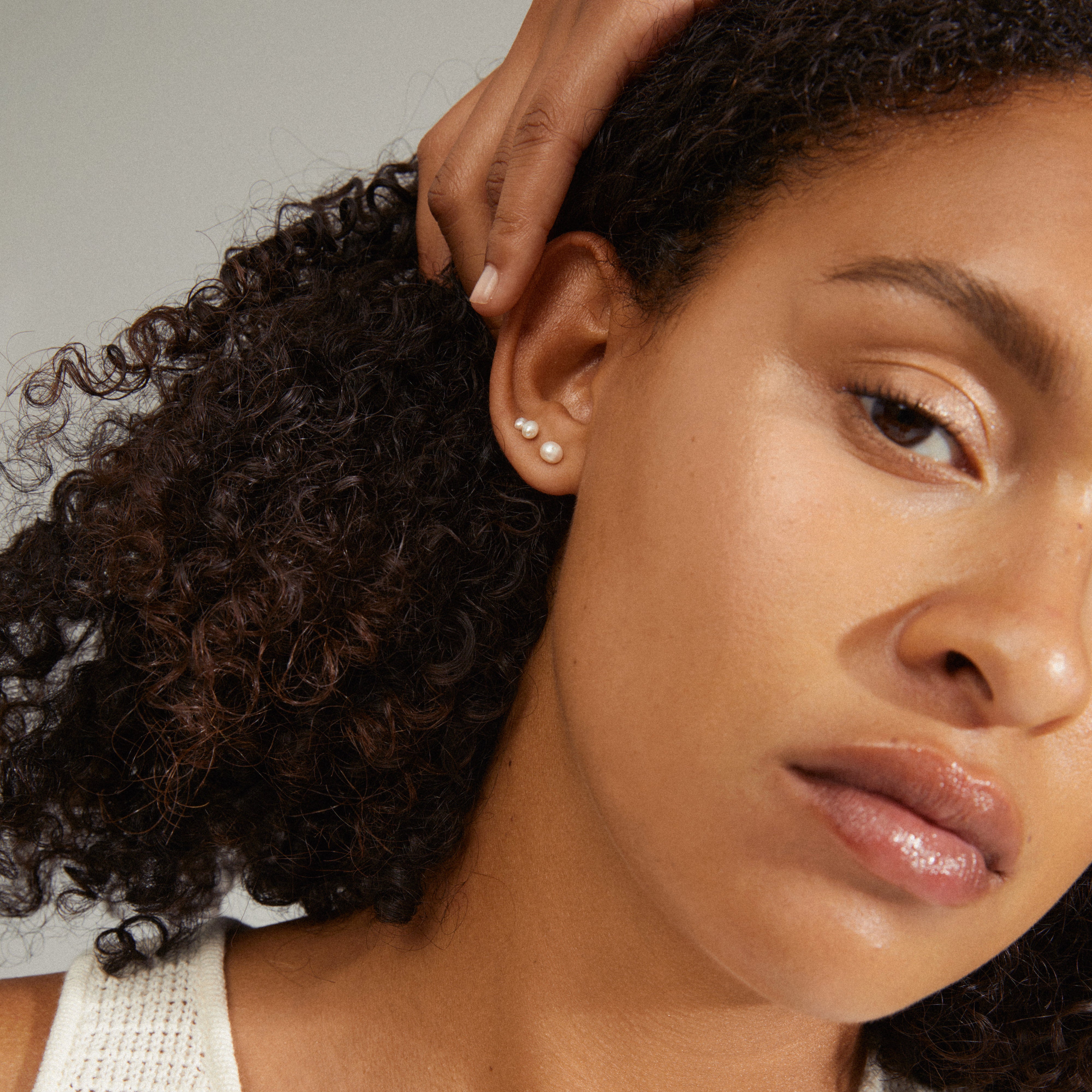 EDIL freshwater pearl earrings 3-in-1 set showcased on a woman with curly hair, highlighting the pearls' elegance and versatile style.