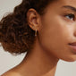 ELNA crystal earrings 2-in-1 set, featuring gold-plated studs and crystal-adorned hoops, beautifully showcased on a woman with curly hair.