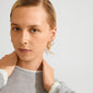 Young person wearing Pilgrim's EVE hoop earrings 2-in-1 gold-plated set, showcasing a stylish ear curation with several thin gold hoops.
