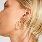 EVE hoop earrings 2-in-1 set gold-plated on ear, showcasing sleek, minimalist styling with a larger and smaller polished gold hoop for versatile elegance.