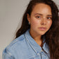 ELFRIDA hoop earrings silver-plated on a woman with long brown hair wearing a denim jacket, showcasing intricate nature-inspired carvings.