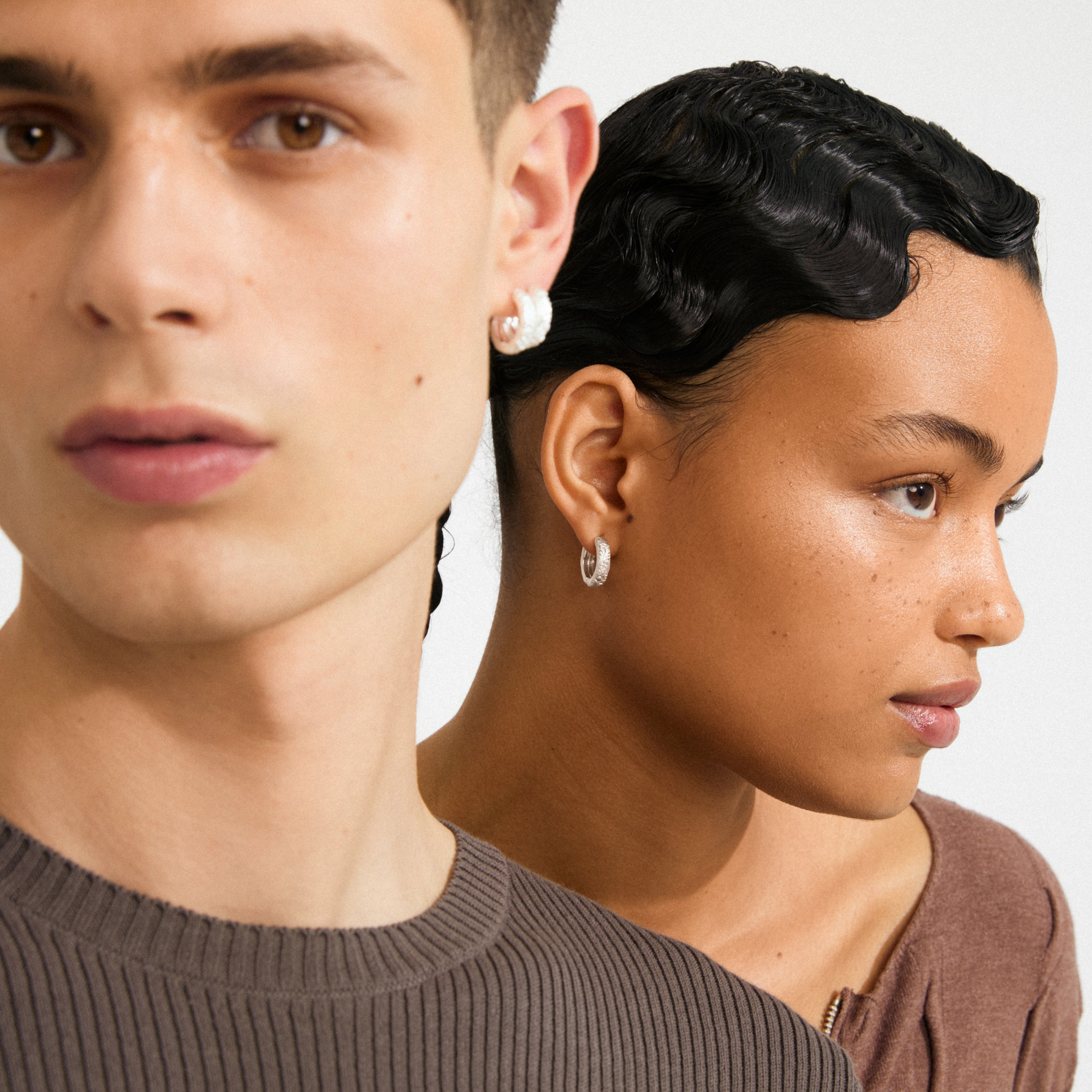 ELFRIDA hoop earrings silver-plated displayed on models, showcasing intricate nature-inspired carvings on wide hoops, highlighting stylish design and sustainable craftsmanship.