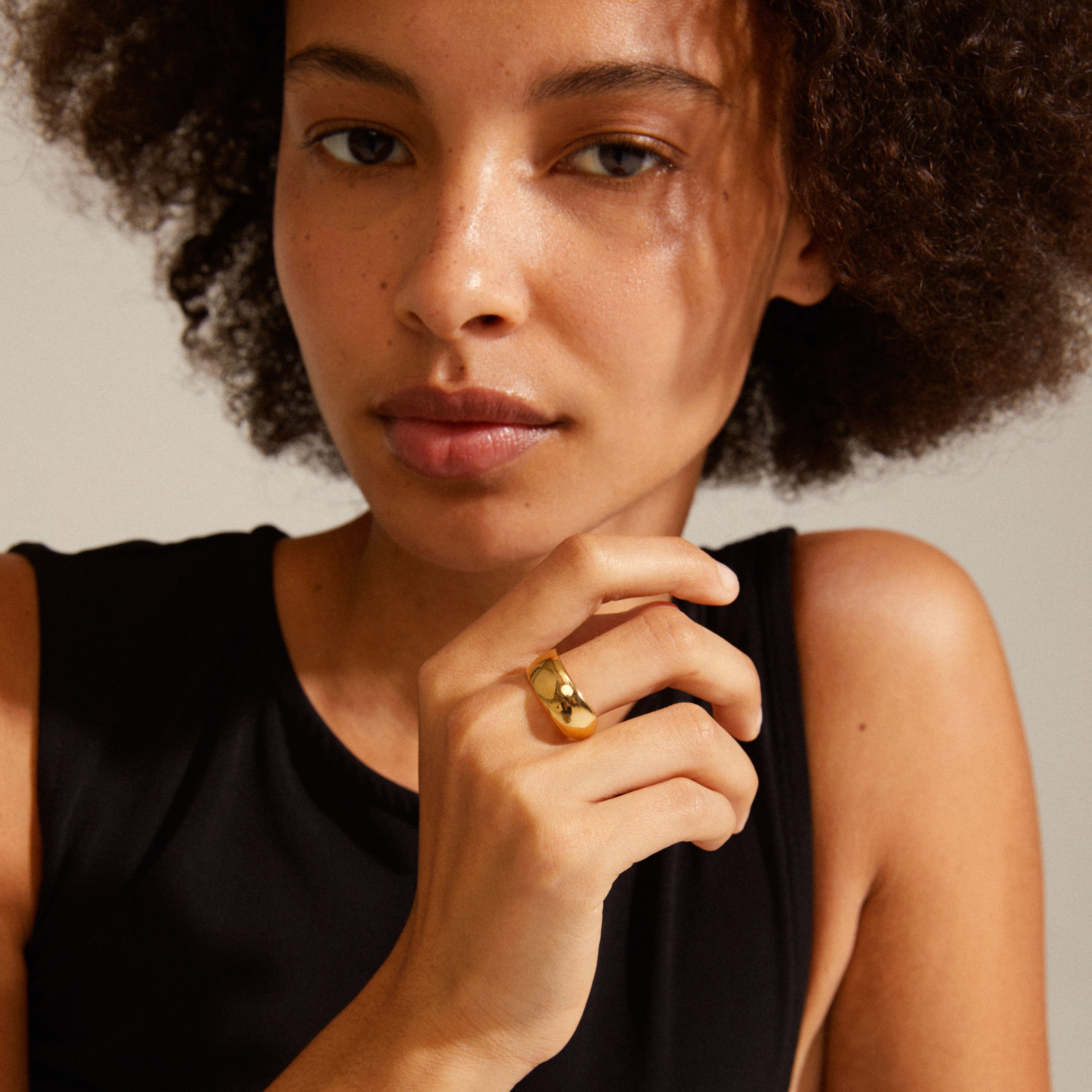 Woman wearing Pilgrim's DAISY ring gold-plated, showcasing its elegant, Nordic-inspired design on her finger. A simple, stylish accessory for any occasion.