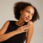 Woman in a black dress wearing the DAISY gold-plated ring by Pilgrim, showcasing its elegant Nordic design and recycled material composition.