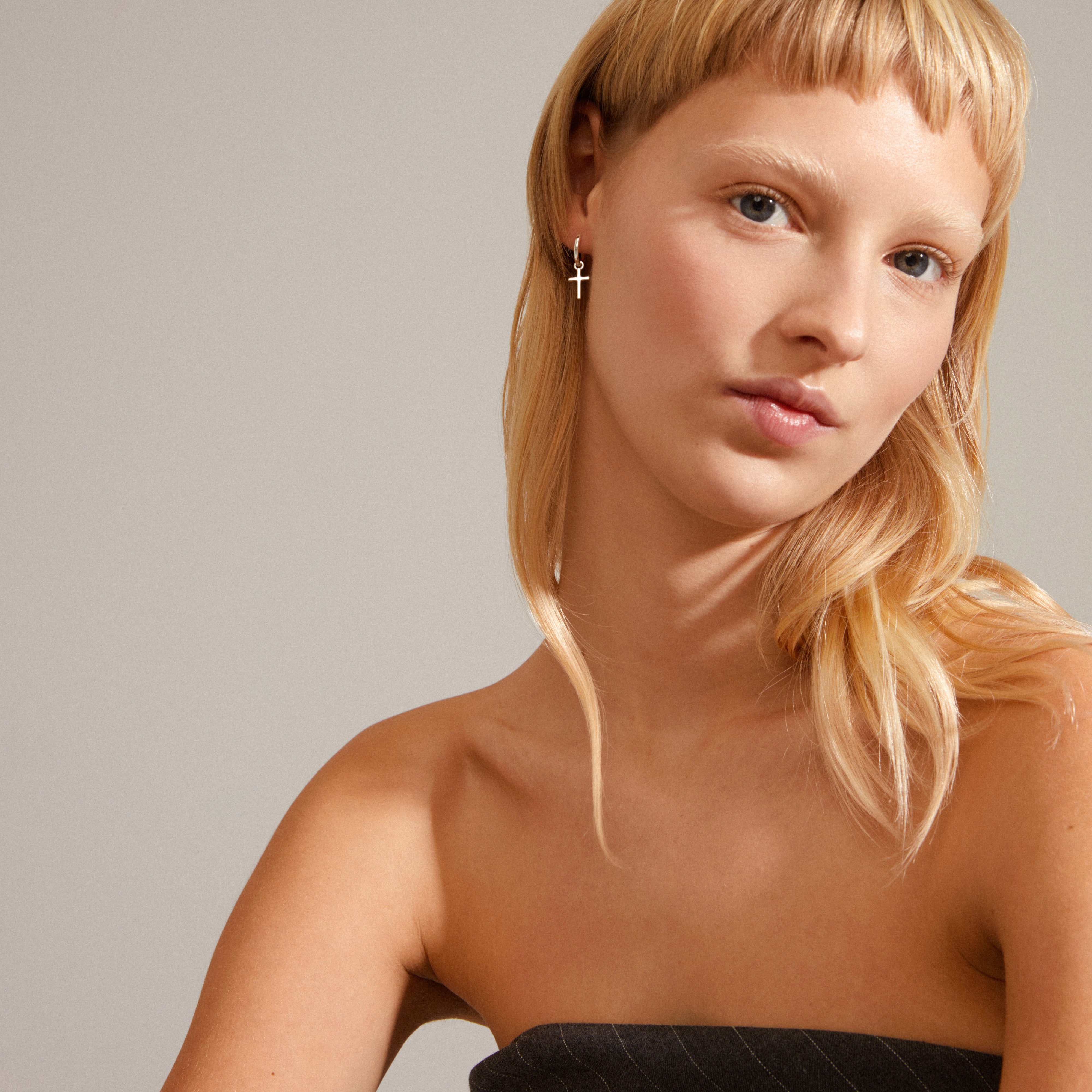 DAISY cross hoops silver-plated, shown worn by a woman with blonde hair, featuring removable cross pendants for customizable style.