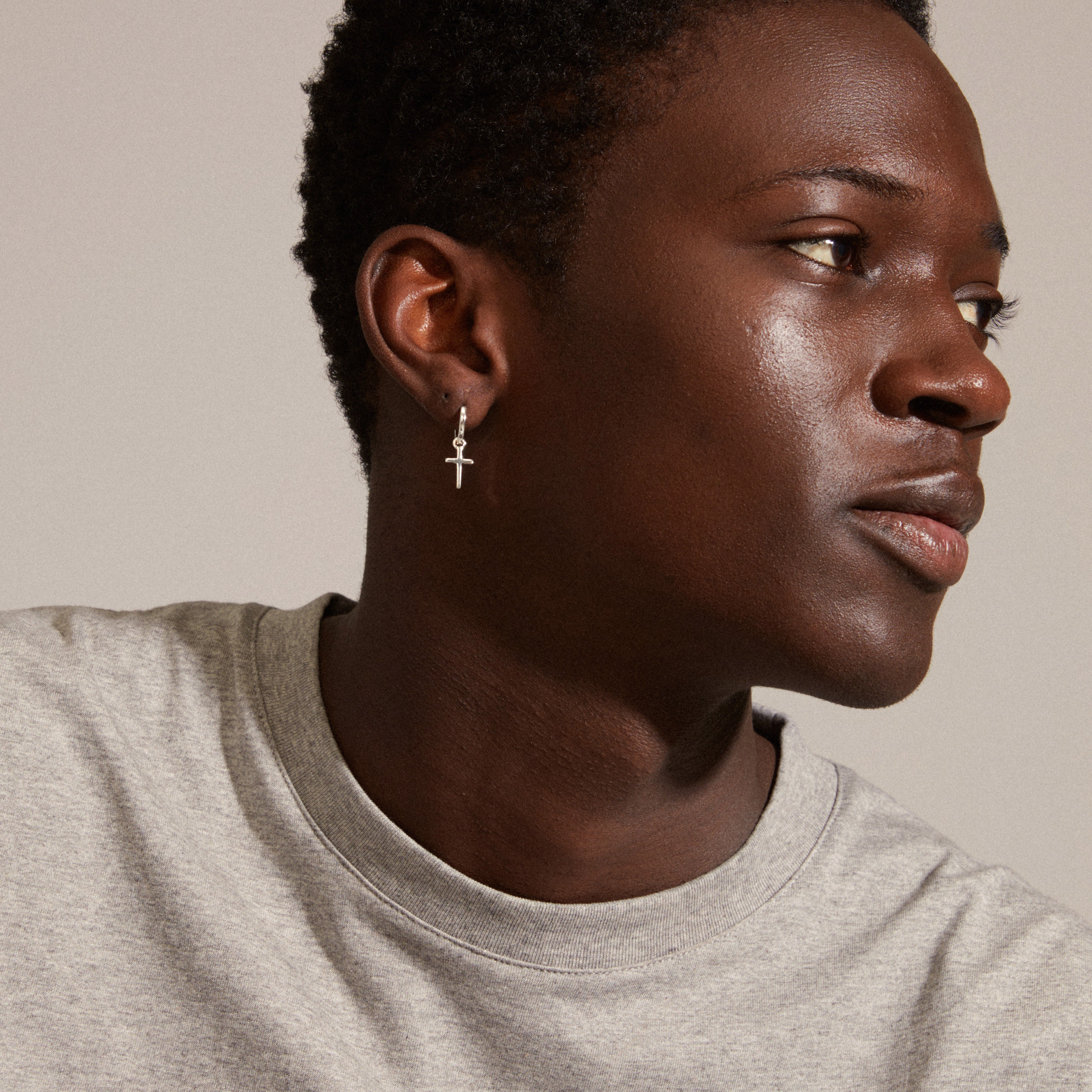 DAISY cross hoops silver-plated earrings worn by a man with short hair, showing the simple design with removable cross pendant for versatile styling.