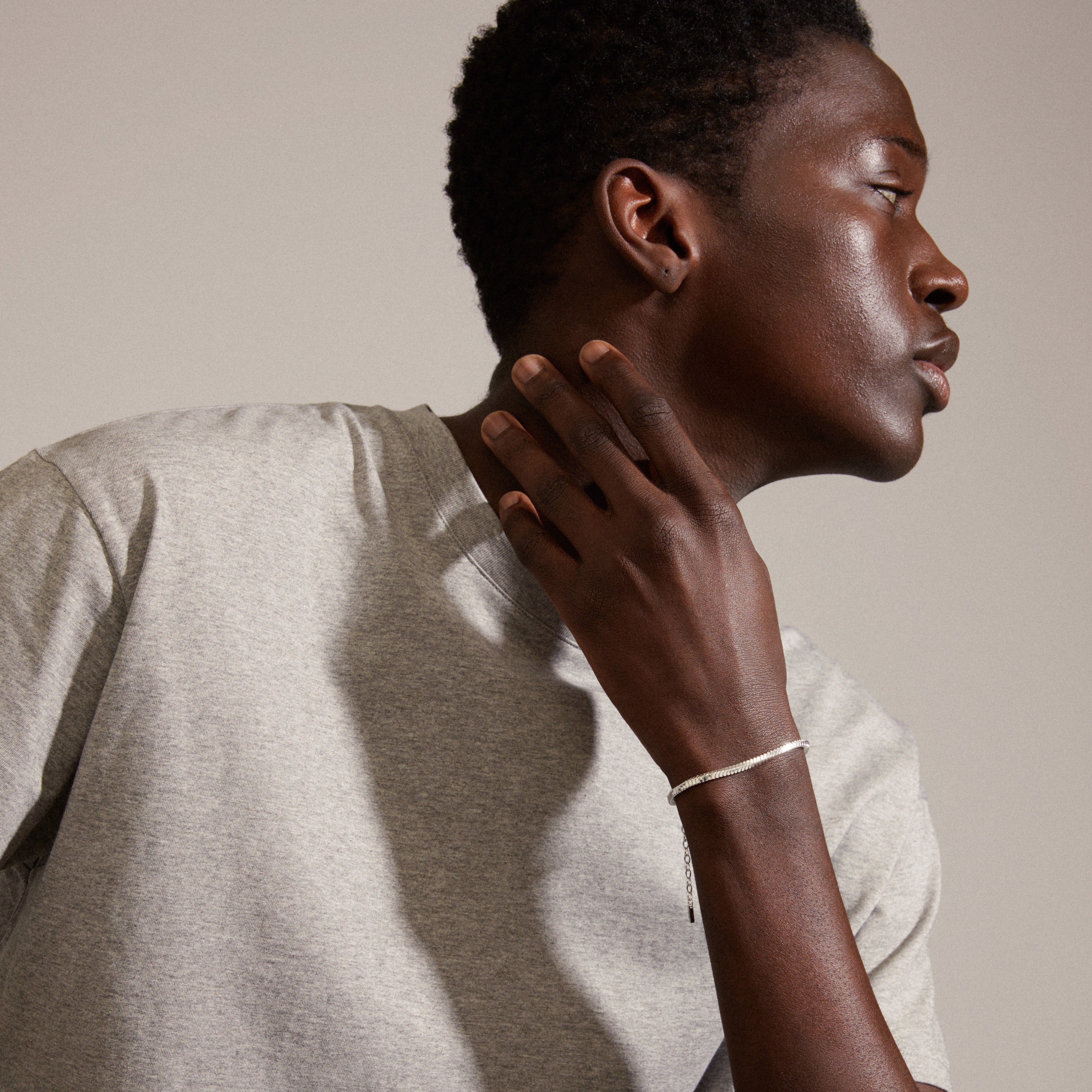Close-up of a man wearing the DOMINIQUE silver-plated bracelet with a square snake design, highlighting its shiny, genderless style from Pilgrim's collection.