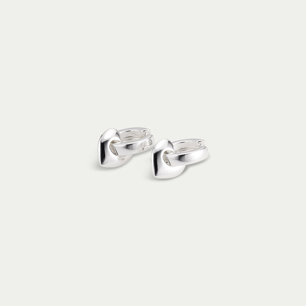 IOKASTE chunky hoops silver-plated earrings featuring wide shiny hoops with removable heart pendants and an easy click lock. Made from 99% recycled materials.