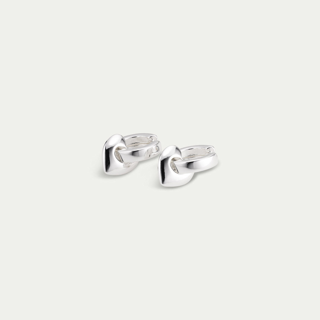 IOKASTE chunky hoops silver-plated earrings featuring wide shiny hoops with removable heart pendants and an easy click lock. Made from 99% recycled materials.