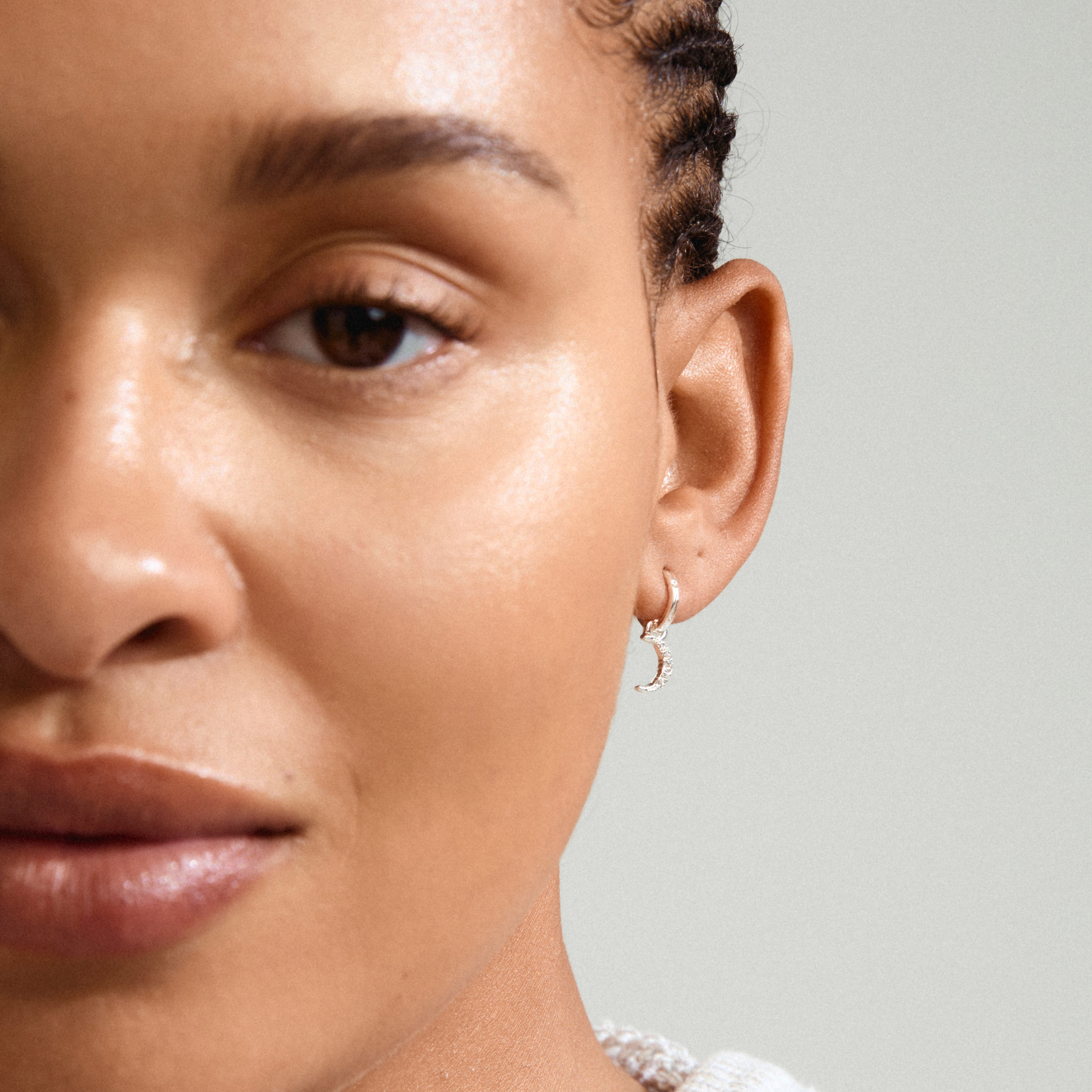 EVGENIA earrings silver-plated, featuring a moon pendant with Preciosa crystals, elegantly hanging from a woman's ear in a close-up. Perfect for a luxe boho look.