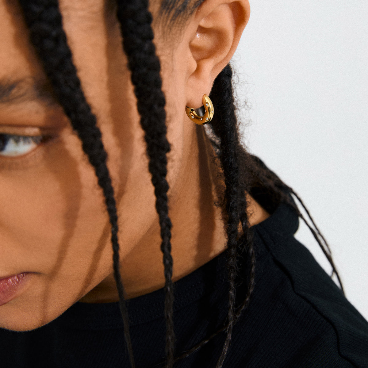 Gold-plated NEVAEH hoops with click clasp and petite Preciosa crystals, designed for a sparkling, versatile look using 97% recycled materials.