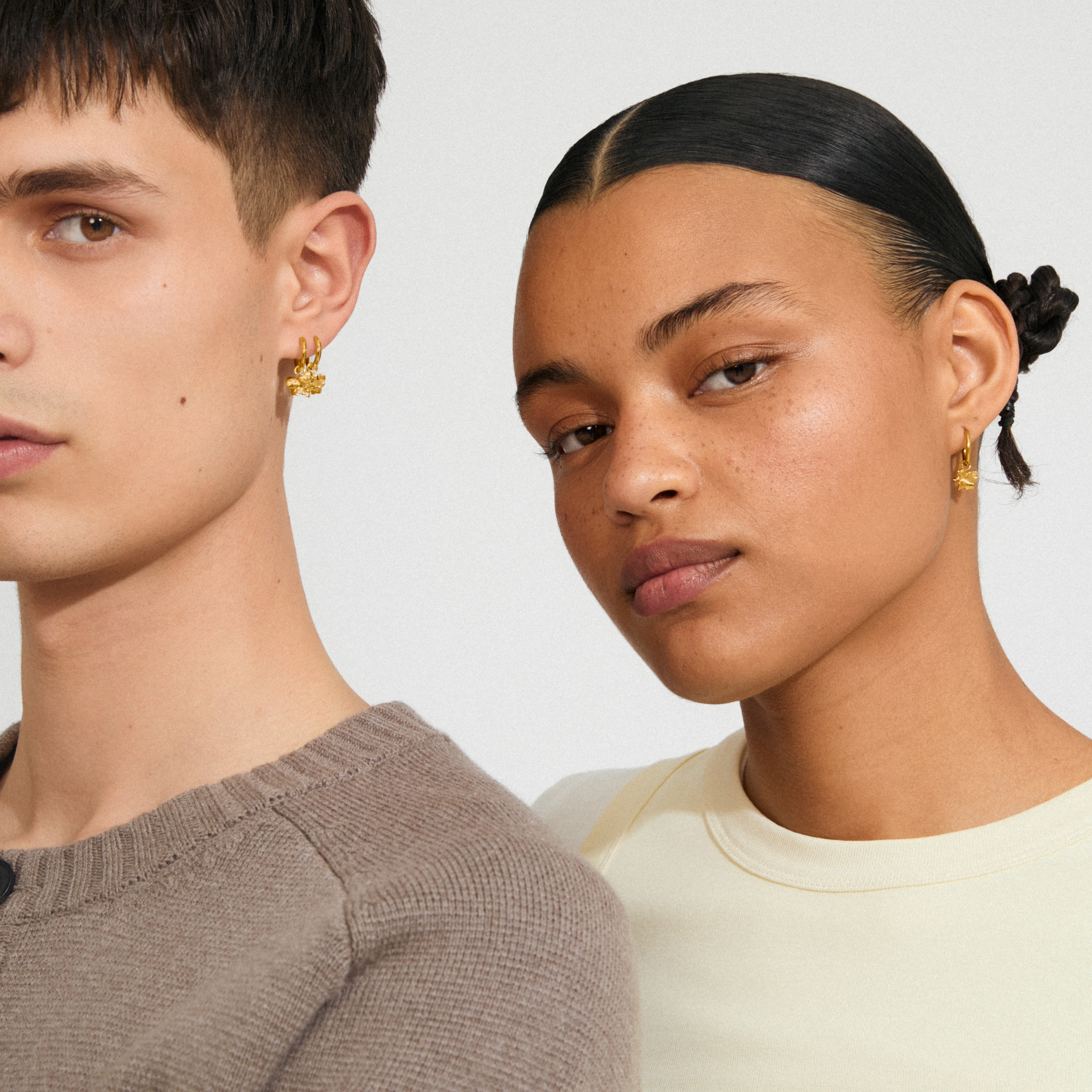 Two models wearing Pilgrim's TIMBER gold-plated earrings with organic flower pendants, showcasing minimalist design and eco-friendly fashion.