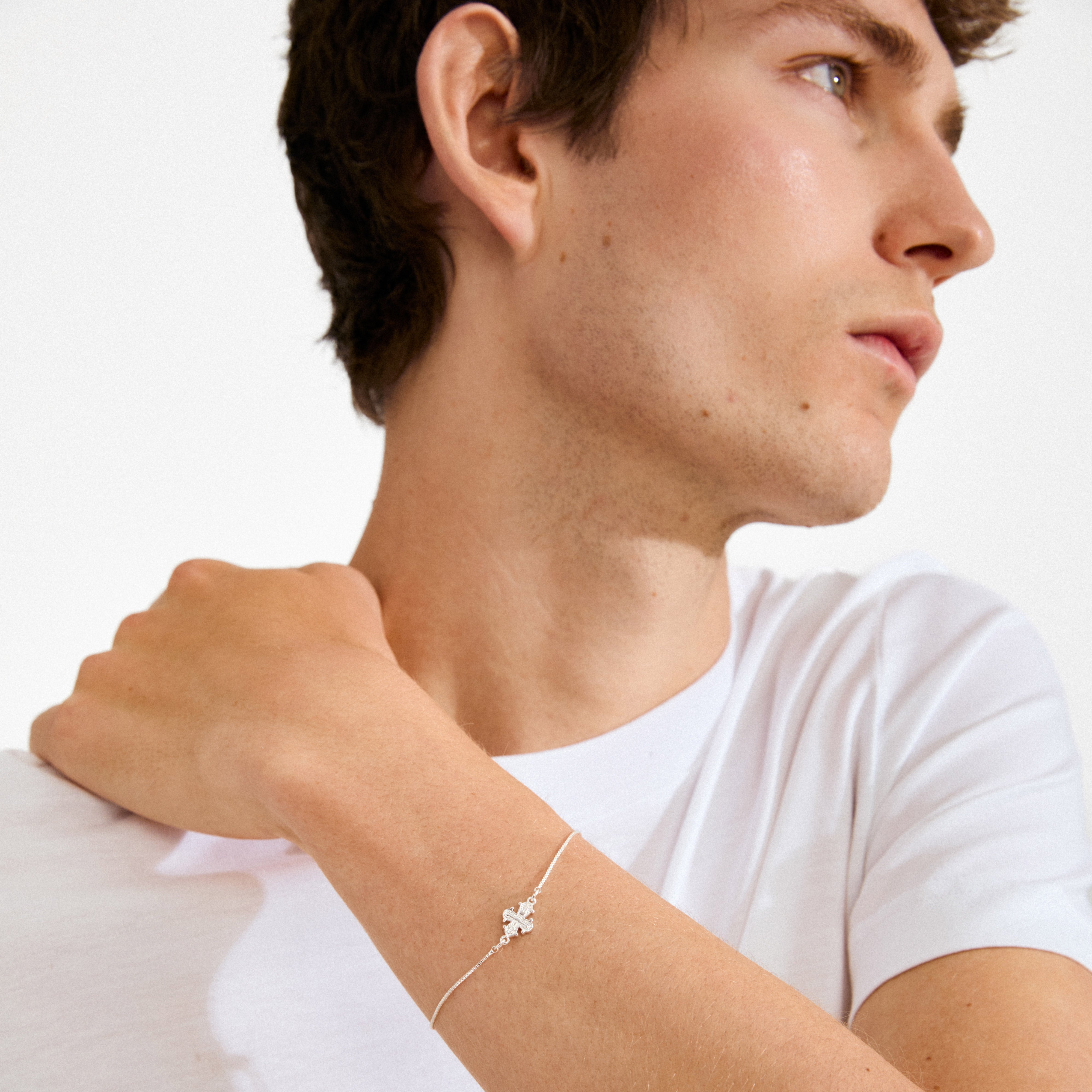Young man wearing the DAGMAR bracelet silver-plated, featuring a four-leaf clover charm on a fine chain, highlighting minimalist Danish design from Pilgrim.