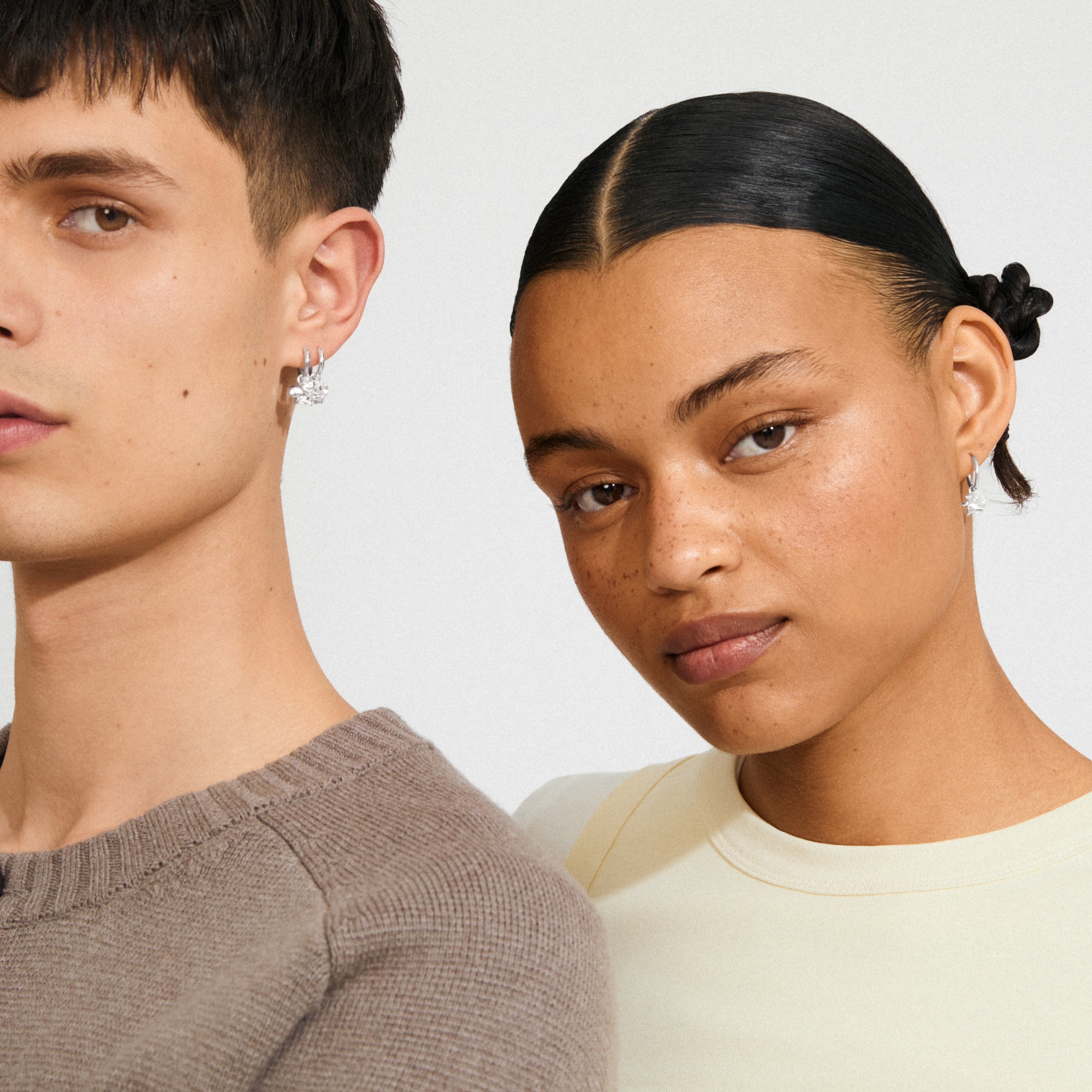 Close-up of models wearing Pilgrim's TIMBER silver-plated earrings with organic flower pendants, showcasing modern, versatile design suitable for daily wear.
