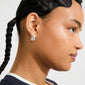 Close-up of a person wearing Pilgrim's BRAXTYN silver-plated chunky hoop earring, showcasing its shiny, smooth dome silhouette and retro-inspired design.