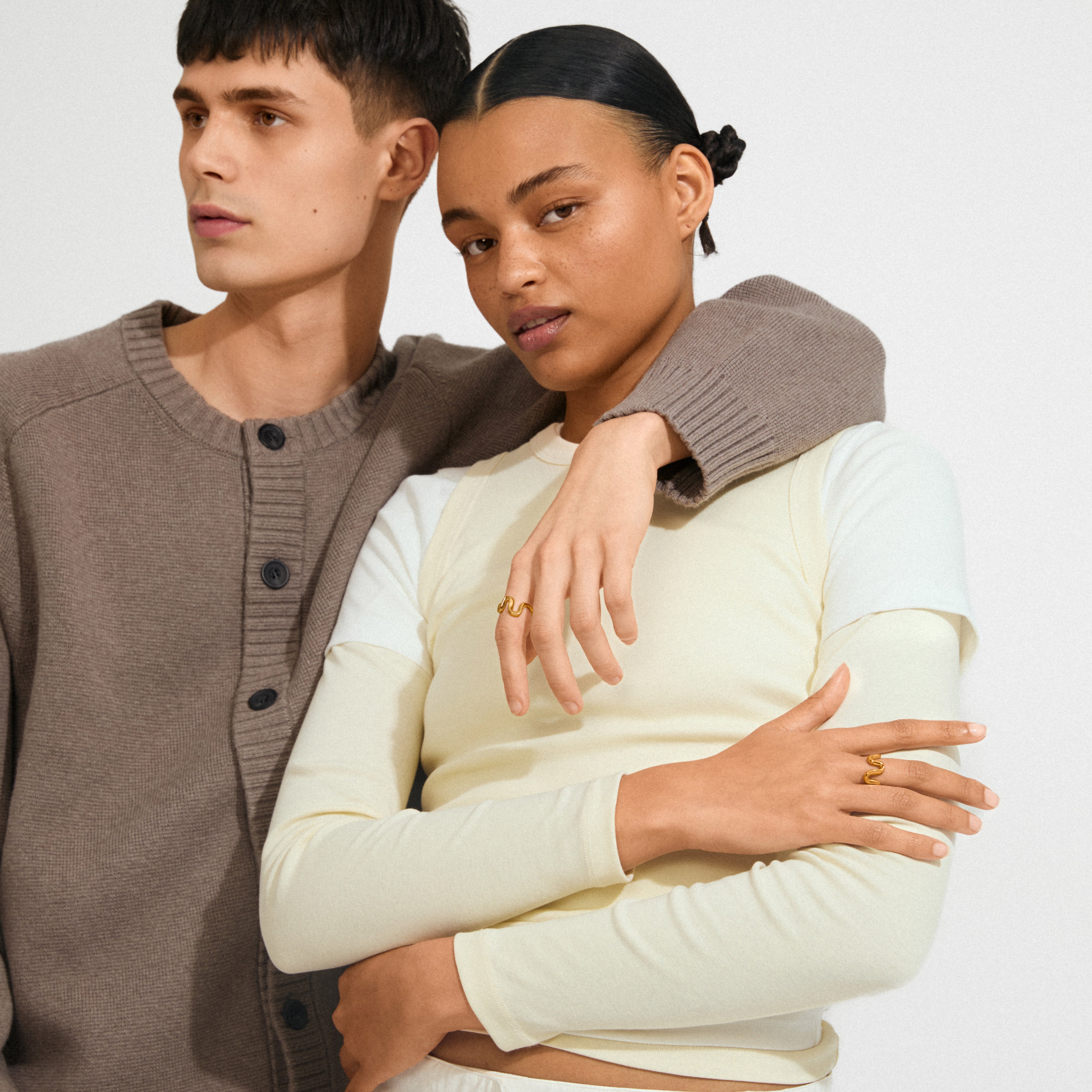 Young adults display AIKO silver-plated rings with wavy designs in a minimalist fashion shoot, highlighting Scandinavian craftsmanship and a stylish, dynamic aesthetic.