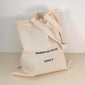 Close-up of Pilgrim's Medium Fashion canvas tote-bag in off-white, featuring wherever you go print and long strap, ideal for daily essentials.