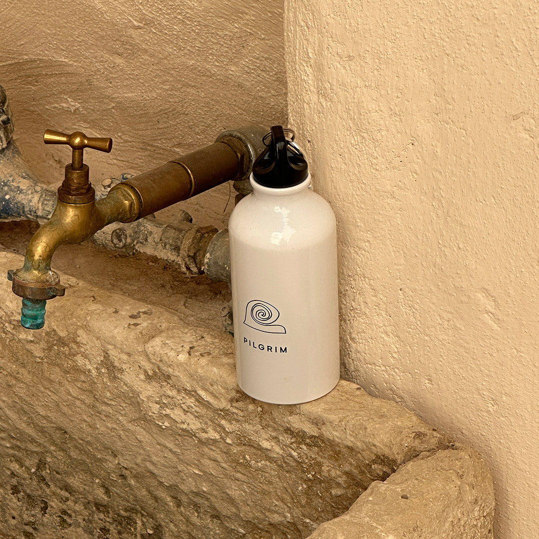 White 400 ml aluminium bottle featuring Pilgrim logo, minimalist design, and practical carabiner for easy carrying. Ideal for beach trips, workouts, and daily hydration.