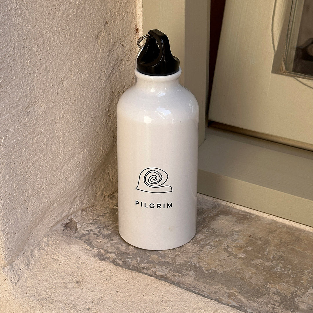 White 400 ml Pilgrim aluminium bottle with logo, featuring a minimalist design and carabiner for easy portability, ideal for active lifestyles.