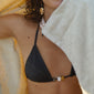 Black triangle bikini with chunky beads and tie-neck halter, featuring high-cut bottoms and side ties, epitomizing effortless beach style.