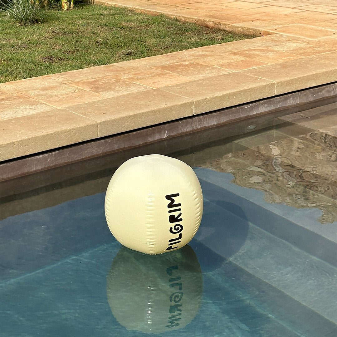 Off-white beach ball with a black Pilgrim logo, 50 cm in diameter, ideal for beach or poolside fun, embodying a playful summer spirit.